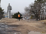 Идет уборка территории возле памятника В.К. Арсеньеву и Дерсу Узала