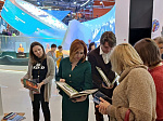 Посетители павильона Приморья на выставке «Россия» знакомятся с детской книгой этнографа Владимира Арсеньева